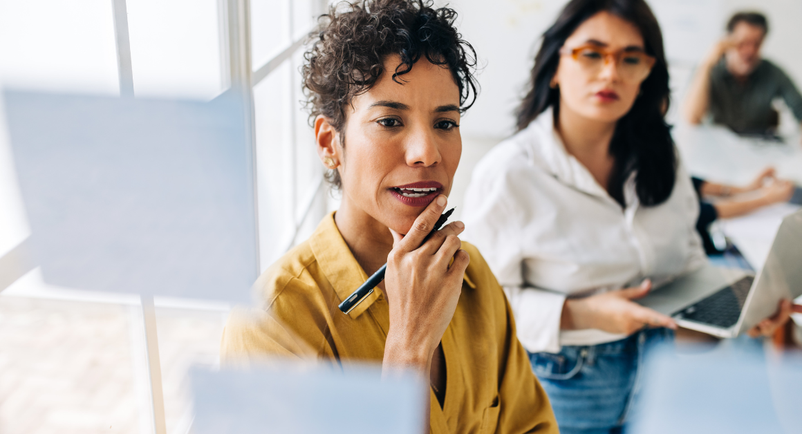 two female marketers looking at a clear white board discussing upcoming marketing trends