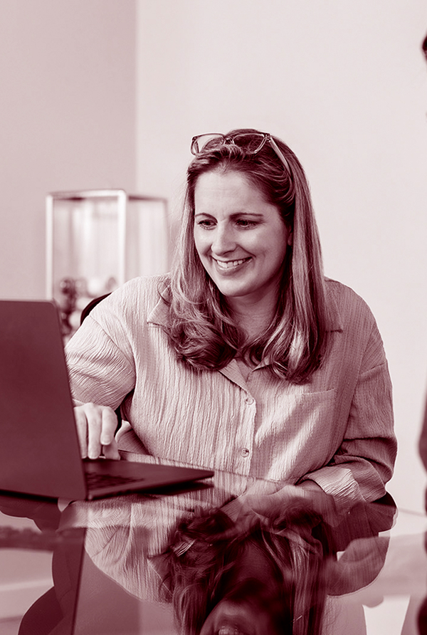 Monica Kolbay is smiling as she works on her laptop